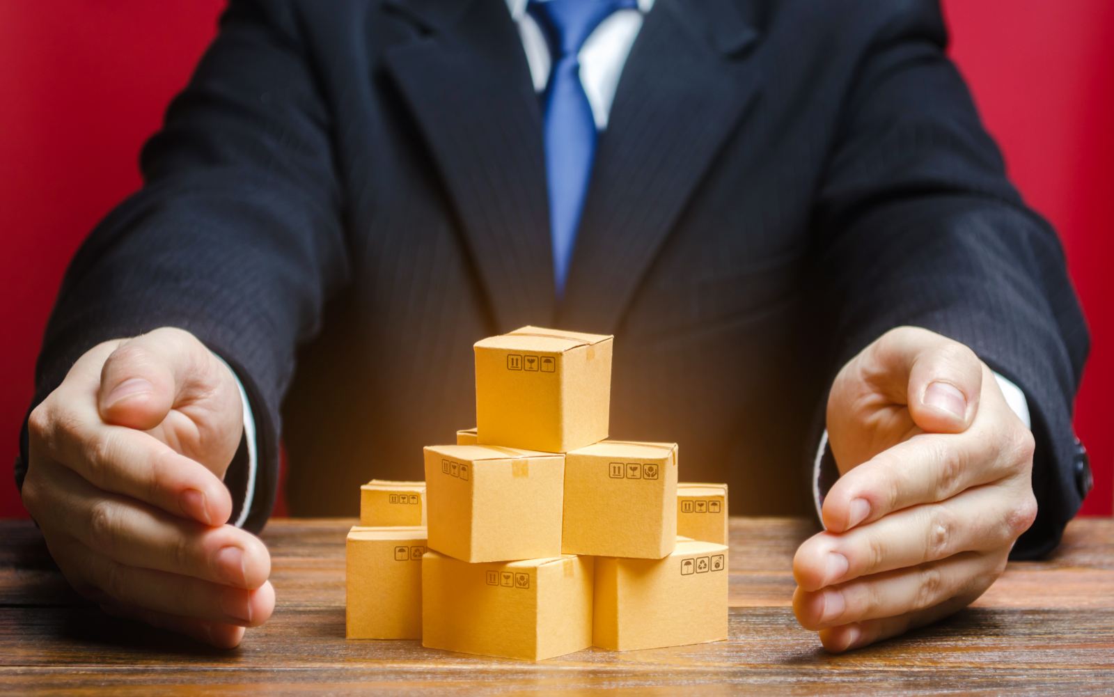 producent otacza dłońmi opakowania zaprojektowane z myślą o recyklingu i spełniające wymogi ekomodulacji