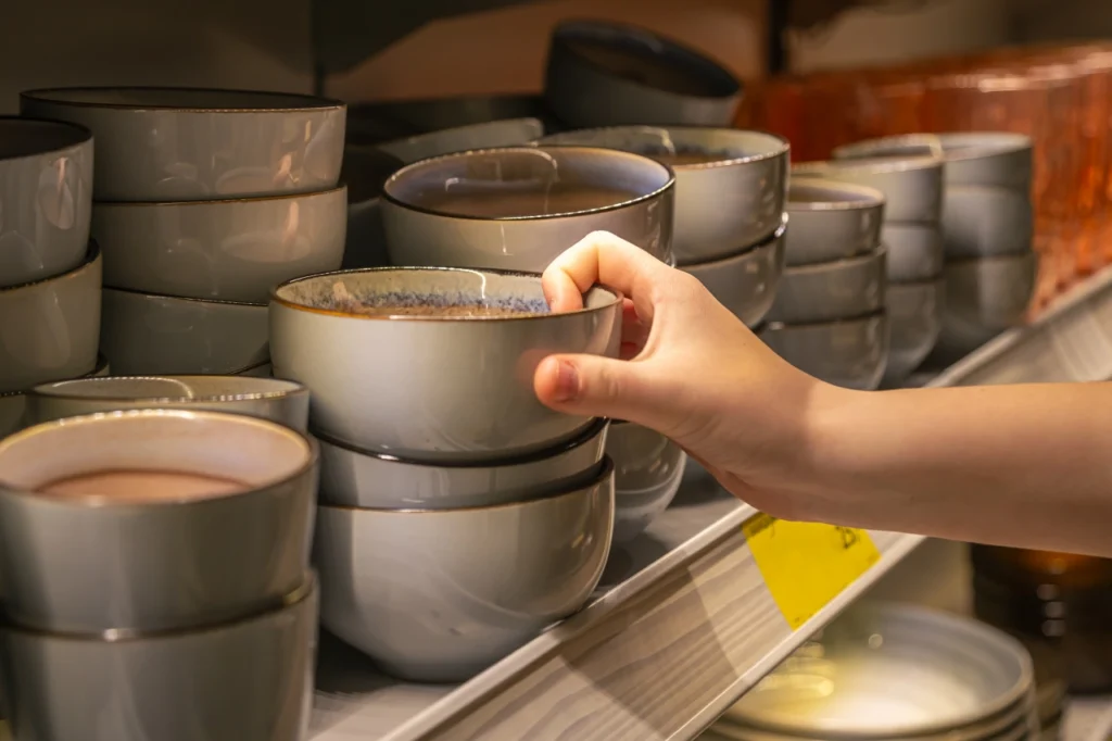 dłoń sięga po miseczkę stojącą na półce sklepu fast homeware